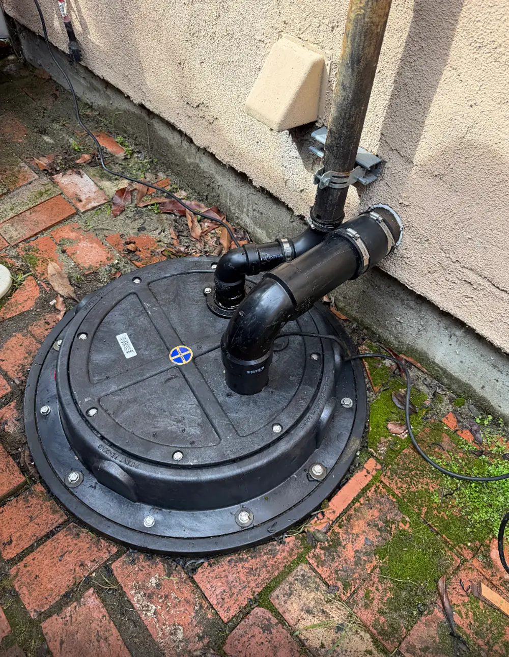Residential sump pump replacement with new sealed sump pit cover, discharge piping, and vent line installed for reliable basement drainage and flood protection.