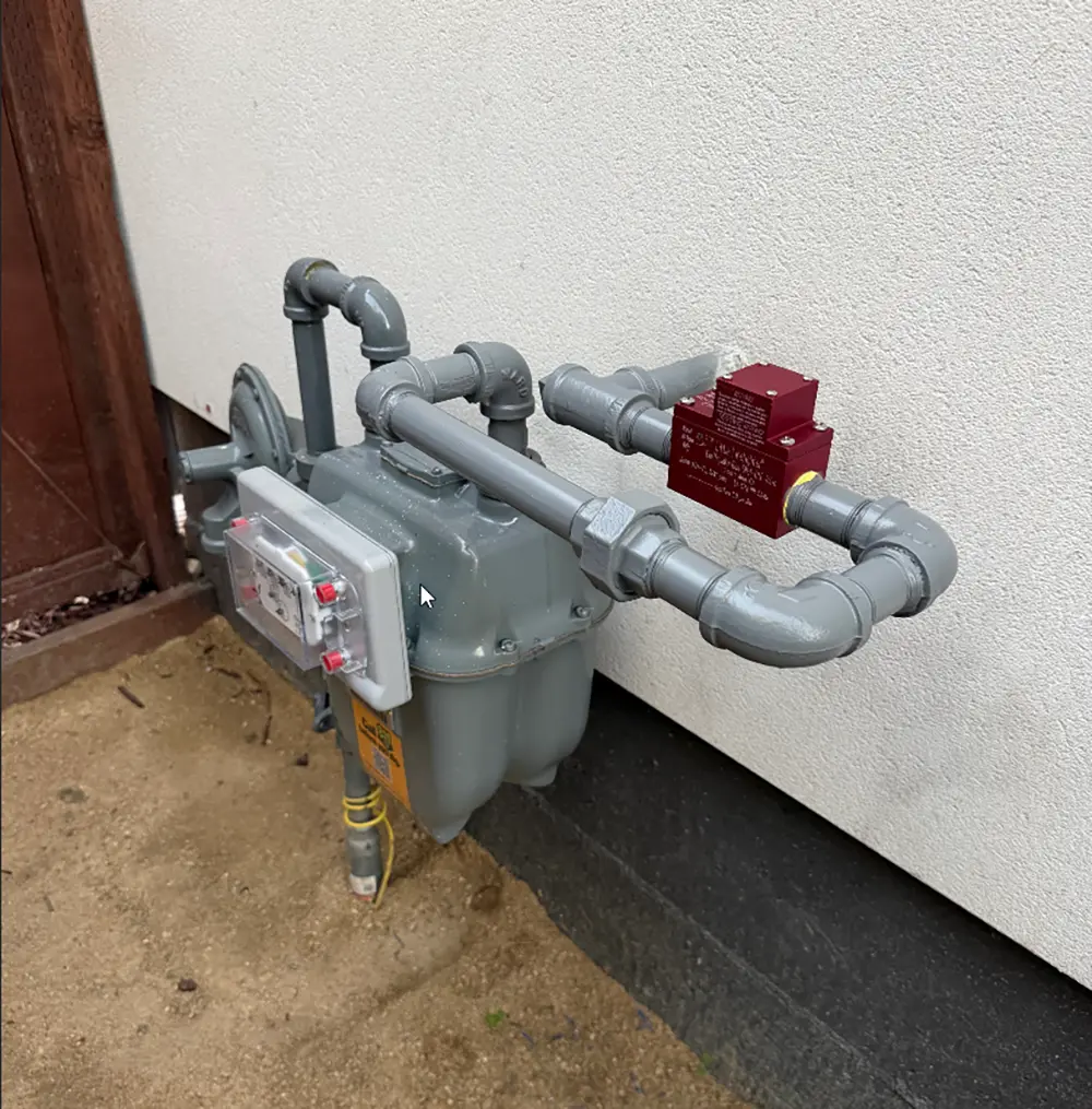 AirGas AirQuick seismic gas shut-off valve professionally installed downstream of a residential gas meter with reconfigured gas piping for automatic earthquake gas protection.