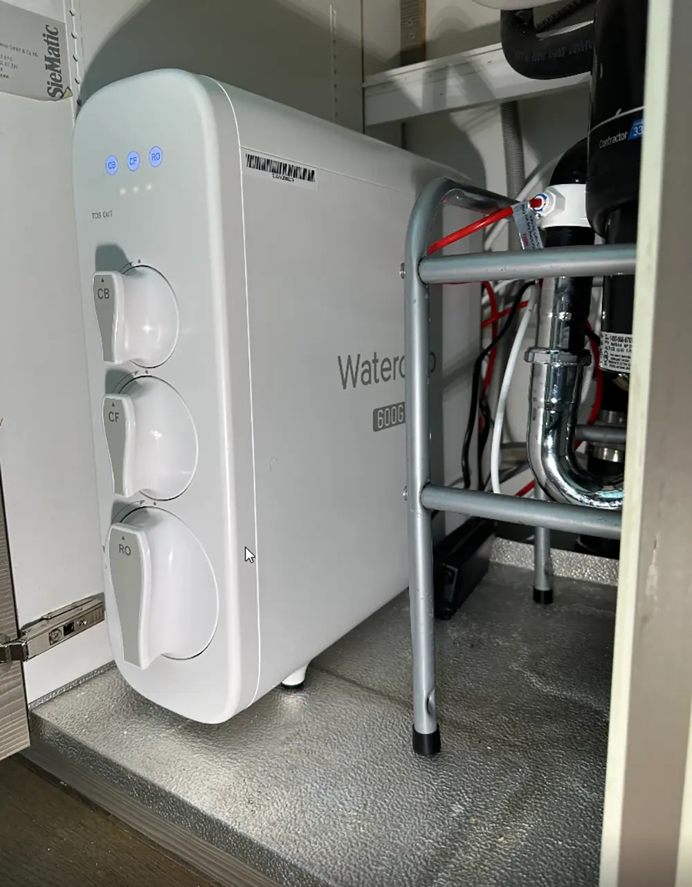 Under-sink reverse osmosis water filtration system and kitchen drain plumbing connected to newly replaced kitchen drain line during residential plumbing upgrade.